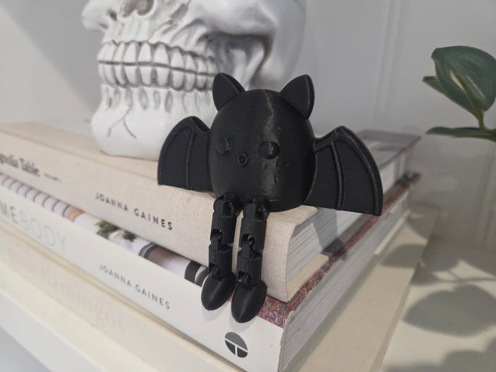 Original photograph of the finished black bat shelf sitter on books