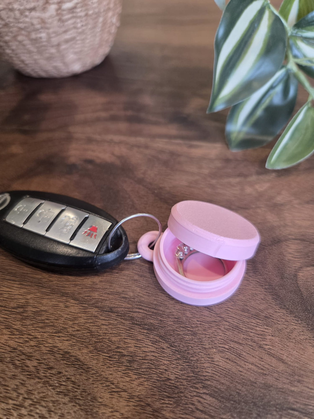 Original product photo of the pink ring holder keychain case open with a ring inside
