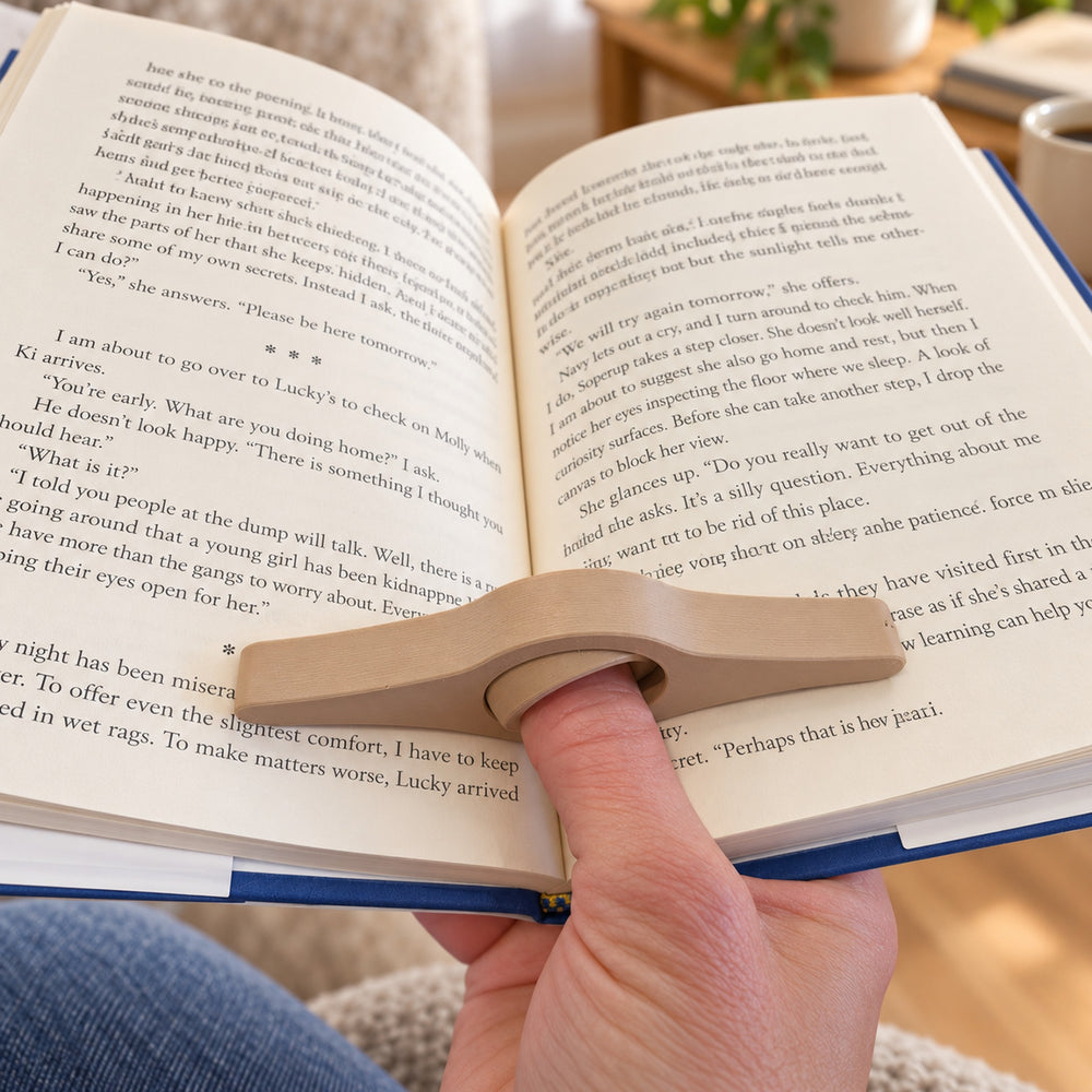 Book page holder worn on a thumb while reading an open book
