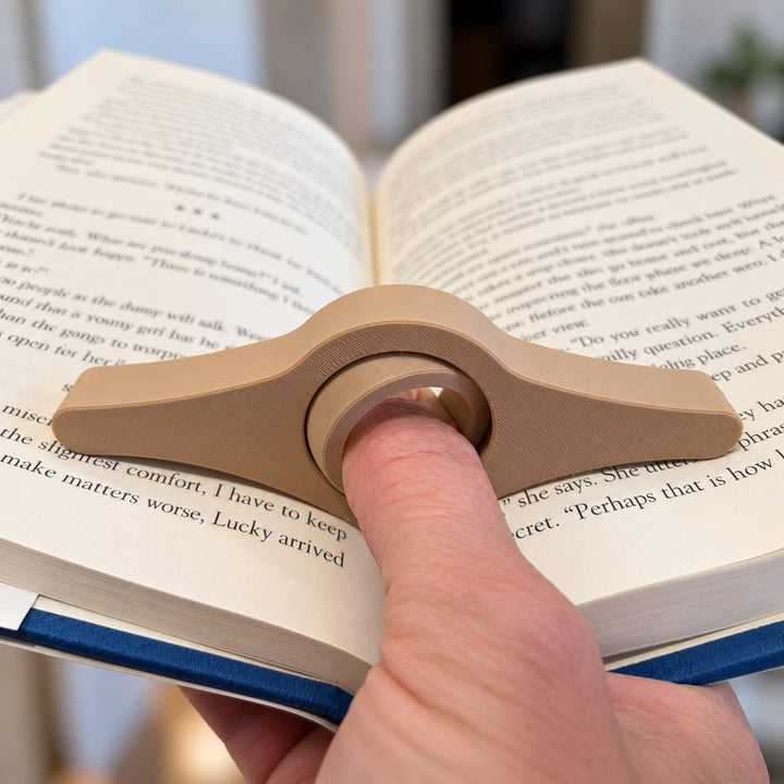 Close-up of the rotating thumb grip supporting open book pages