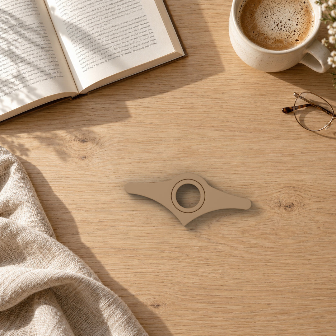 Book page holder on a wooden table beside a book and coffee