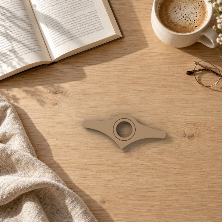 Book page holder on a wooden table beside a book and coffee